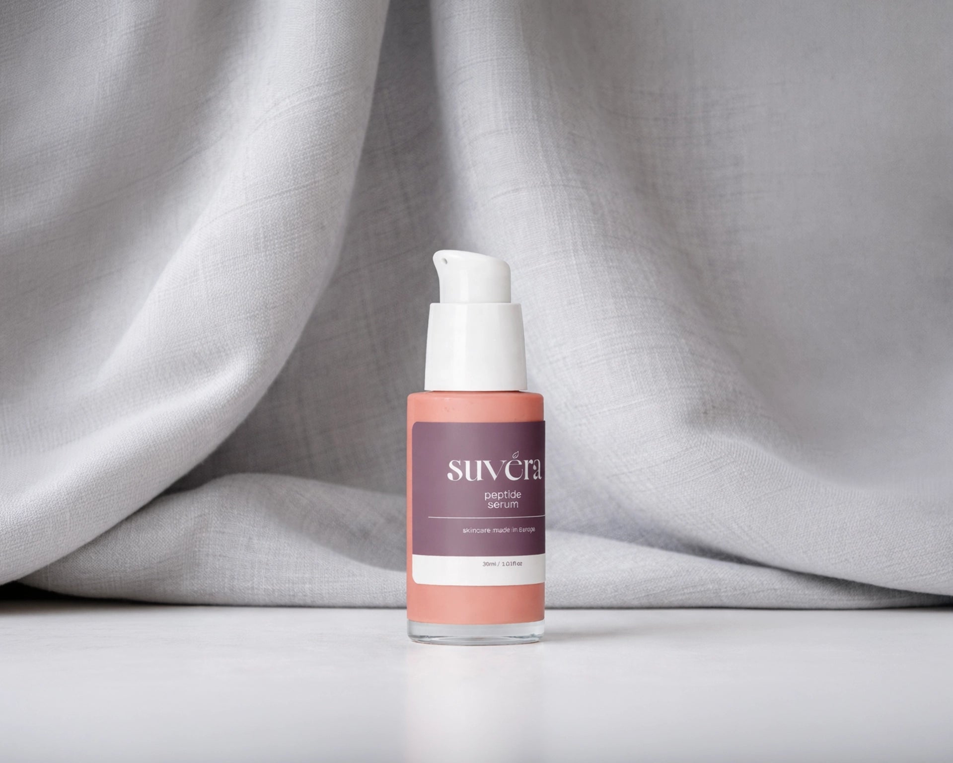 Skincare serum bottle with visible brand name on a gray fabric background Suvera Peptide Serum Botox