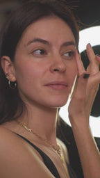 Female skincare model applying serum on face eyes